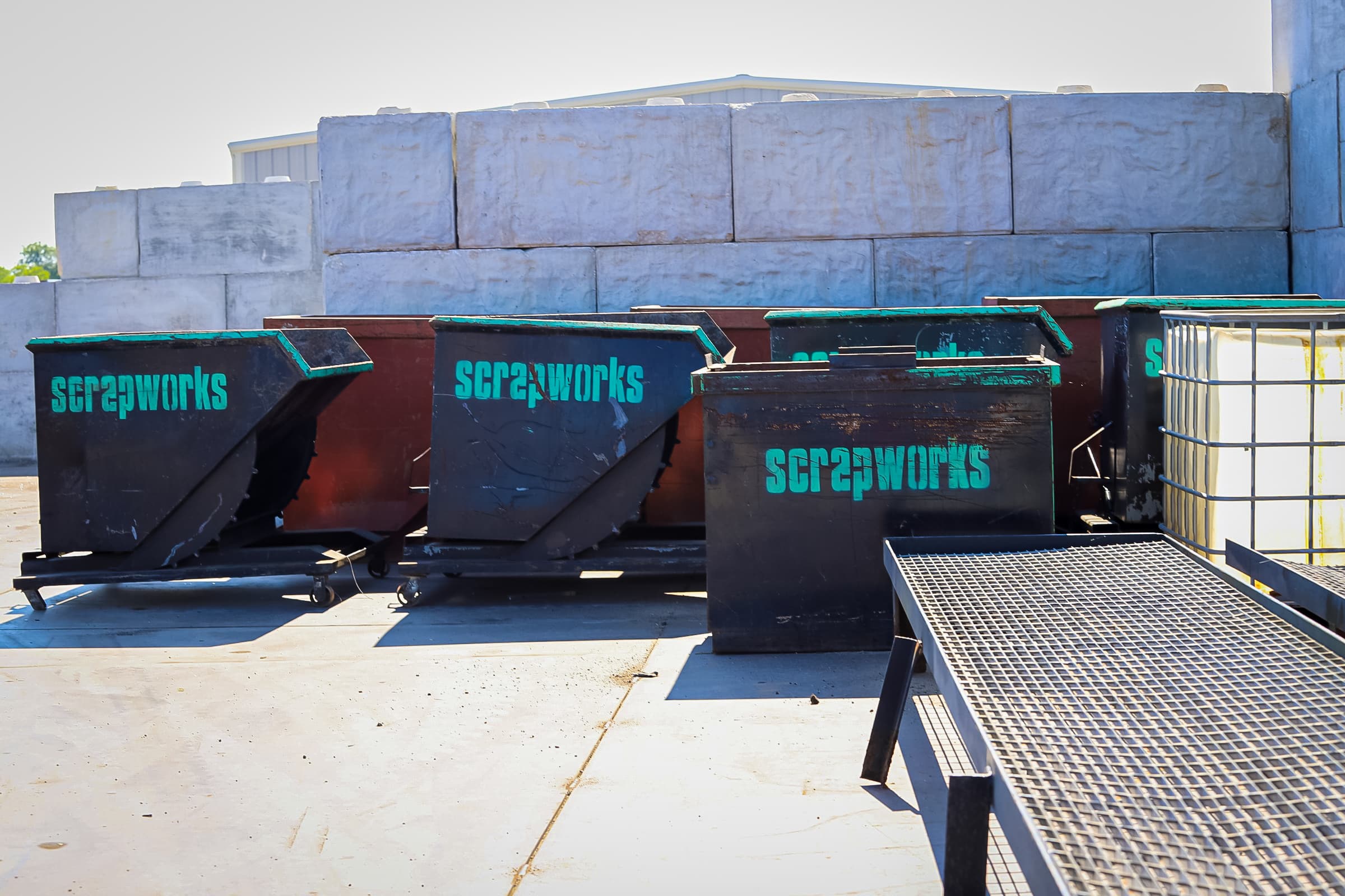 Forklift loading scrap into roll-off containers at a Scrapworks yard